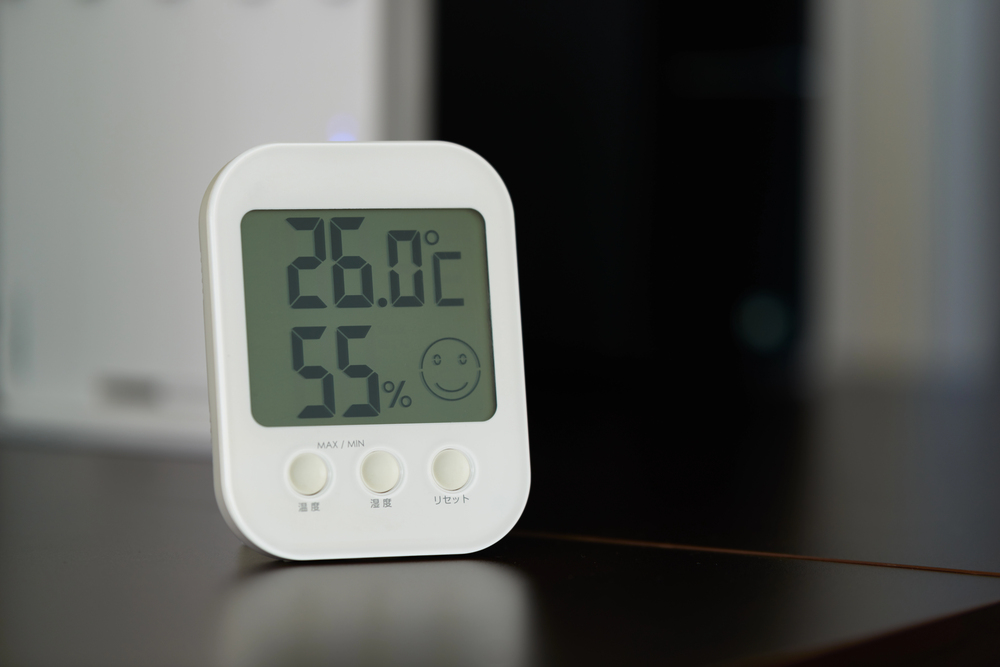 Digital hygrometer measuring room humidity while air conditioner is running